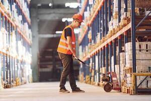 Side view of warehouse worker that is in uniform and hard hat working with cargo photo
