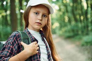 Portrait of girl that is in the forest at summer day time discovering new places photo