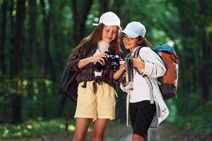 Front, view of two girls that is in the forest having a leisure activity photo