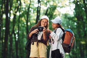 Front view of two girls that is in the forest ,having a leisure activity photo