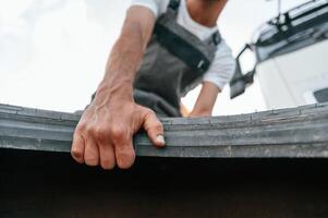 With broken tire. Man, in unifrom doing service for big truck vehicle photo