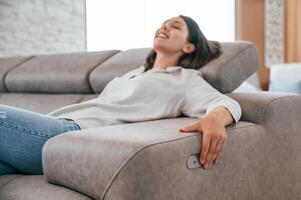 Trying automatic switches. Woman is visiting bed store. Looking for comfortable sofa photo