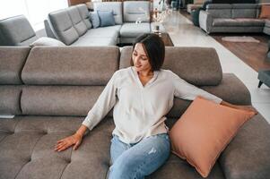 Woman ,is visiting bed store. Looking for comfortable sofa photo