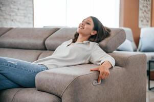Trying, automatic switches. Woman is visiting bed store. Looking for comfortable sofa photo