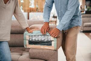 Smooth material. Couple, choosing the sofa and bed in the store photo