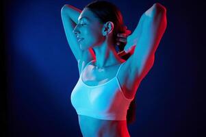 Feeling relaxed. Young. woman in underwear is in the studio with neon lights photo