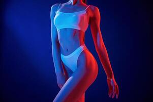 Close ,up view. Young, woman in underwear is in the studio with neon lights photo