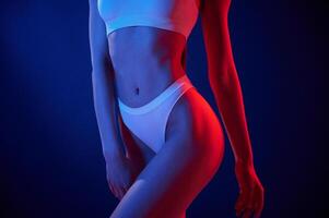 Close up view. Young ,woman in underwear is in the studio with neon lights photo