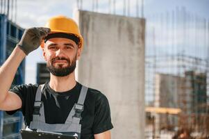 Posing for, a camera, with notepad. Beautiful portrait. Man in uniform is working on the construction site photo