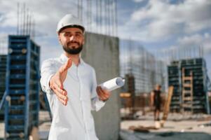Making a deal. Extending the hand. Man in uniform is working on the construction site photo