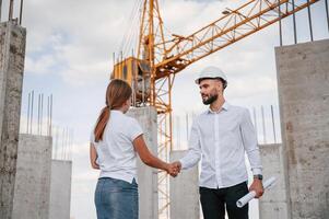 Doing ,handshake. Successful agreement. Man in uniform working with woman on the construction site photo