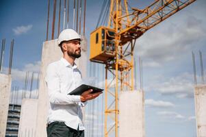 Inspector with notepad is ,standing on the construction site photo