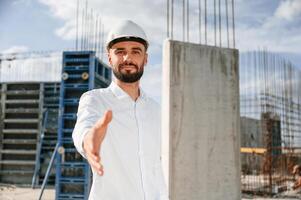Engineer ,extends his hand. Man in uniform is working ,on the construction site photo