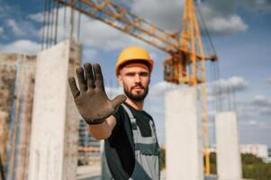 Stop ,gesture. Man in uniform is working on the construction site photo