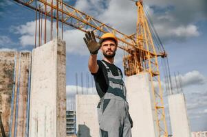 Stop gesture.. Man in uniform is, working on the construction site photo