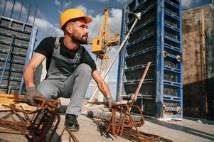 Metal pieces ,covered in rust. Man in uniform is working on the construction site photo