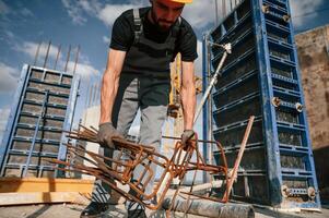 Metal pieces covered in rust. Man in uniform is working on the construction site photo