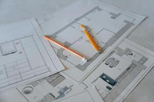 Close up view of plan of building repaiting and contruction that is on the floor with yellow pencils on it photo