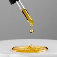 A drop of oil being poured into a glass photo