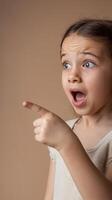 A young girl pointing at something with an open mouth photo