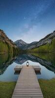 A wooden dock with a lantern on it in front of a lake photo