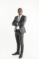 A young african man in a suit and tie standing with his arms crossed photo