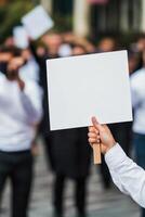 A person holding up a blank sign in front of a crowd photo
