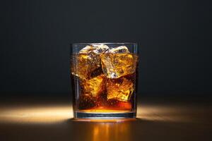 A glass of cola with ice cubes on a table photo