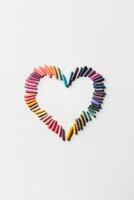 Heart shape crafted from colorful crayons on a white background showcases the joy of artistry and imagination photo
