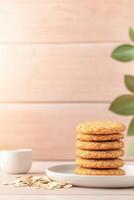 Delightful stack of homemade ANZAC biscuits served with oats and golden syrup on a rustic wooden background photo