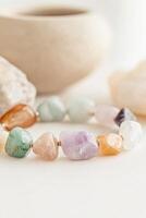 Vibrant gemstone bracelet showcasing a stunning array of colors on a light tabletop setting photo