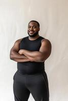 Full-figured man confidently showcases athletic style against a minimal backdrop while embodying comfort and positivity photo