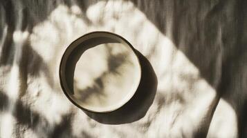 Empty ceramic plate on a linen tablecloth showcasing simplicity and elegance in a serene setting photo
