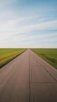 An empty road in the middle of a field photo