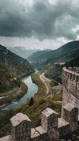 The view from the top of the wall of a castle overlooking a river photo