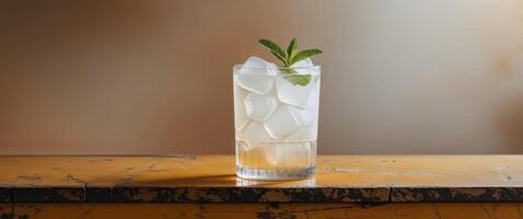 Refreshing drink served in a glass filled with ice on a wooden bar top in a casual setting. photo