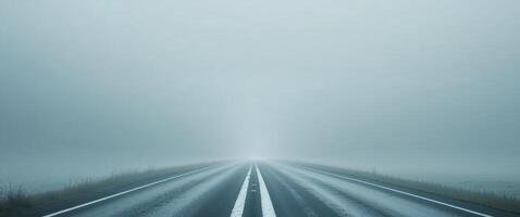 Empty foggy road with a clear dividing line and minimal landscape visibility in the background Copy Space. photo