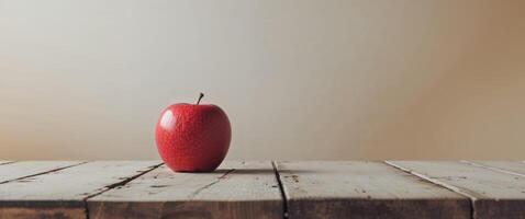 A red apple sitting on top of a wooden table photo
