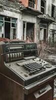 An old, rusted, broken down cash register is sitting in front of a building photo