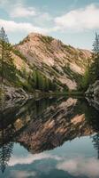 A mountain lake with trees reflected in it photo