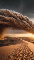A sand dune is blowing in the wind at sunset photo
