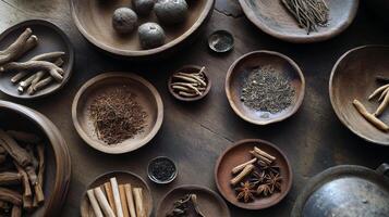 Diverse selection of traditional dried herbs and spices in wooden bowls on rustic table photo