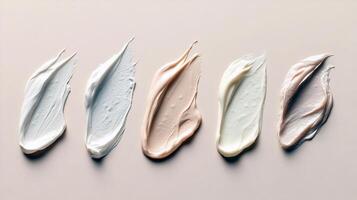 Assorted cosmetic cream smears in neutral shades on beige background photo