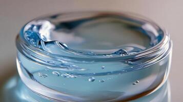Refreshing blue gel in clear glass bowl on light blue surface photo
