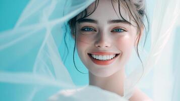 Smiling young caucasian female bride with veil on blue background photo