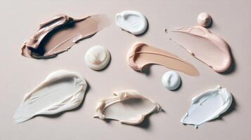 Various shades of foundation and cream on beige background photo