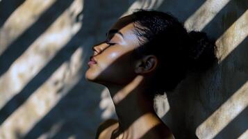 Young asian female relaxing in sunlight with patterns of light and shadow photo
