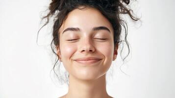 Young caucasian female with curly hair smiling peacefully with closed eyes photo