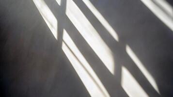 Sunlight casting window shadows on a wall in a minimalist setting photo