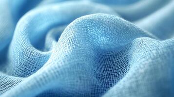 Close-up of light blue fabric texture with soft waves and linen weave photo